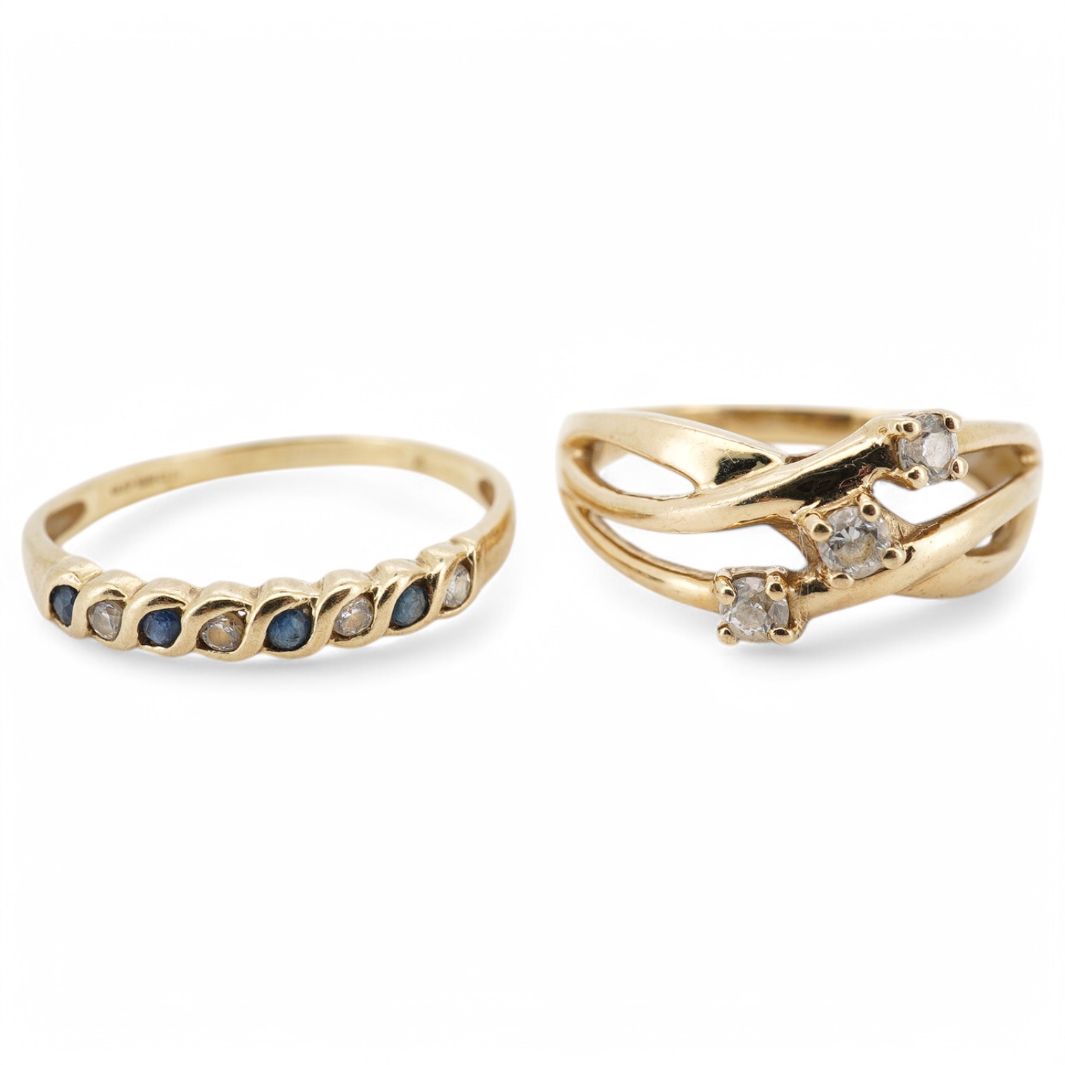 A modern 9ct gold and three stone cubic zirconia set crossover ring, size L, together with a 9ct gold and gem set half hoop ring, size M, gross weight 3.4 grams. Condition - fair